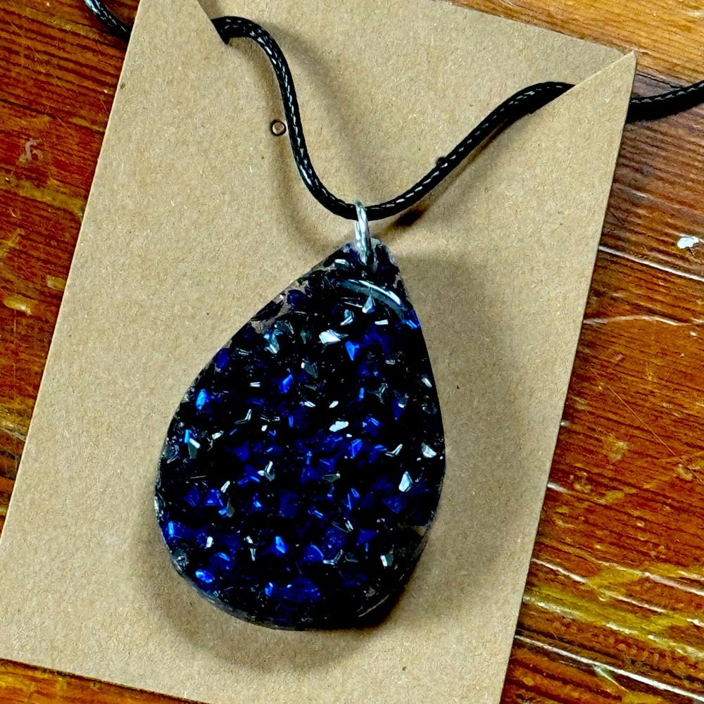 Dark blue and dark silver pendant on a black necklace. 16+2 inch
